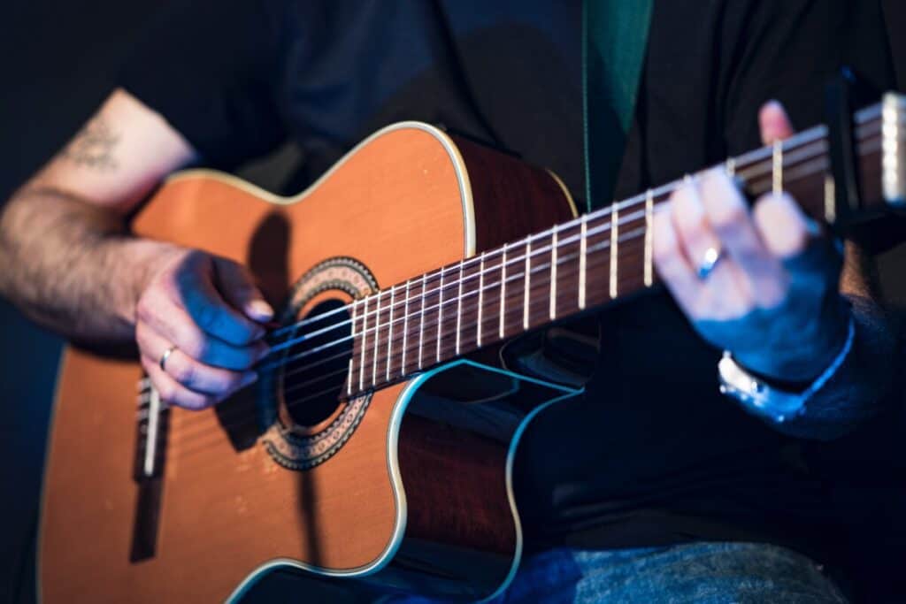 person playing fingerstyle guitar
